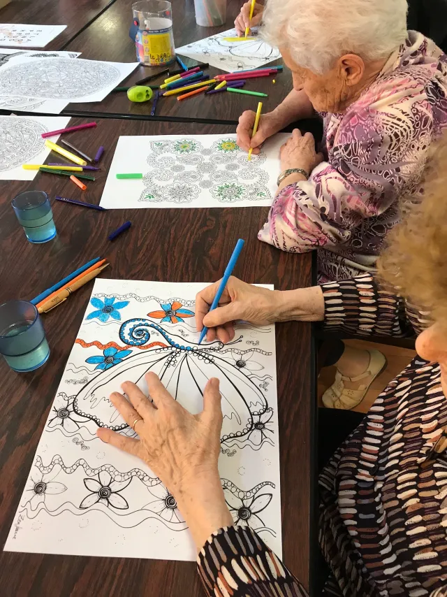 Une participante choisit les couleurs de son mandala pendant un atelier.